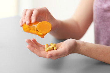 Woman taking vitamins, closeup
