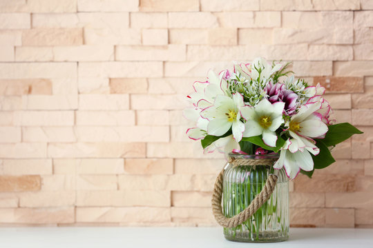 Bouquet of spring flowers on brick wall background