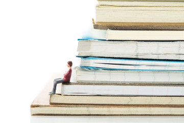 ノートの束に座っている男性