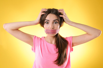 Woman with locked mouth for diet on yellow background