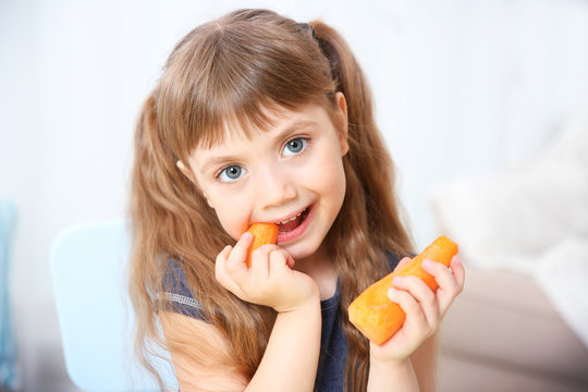 Little girl with carrot in the living room