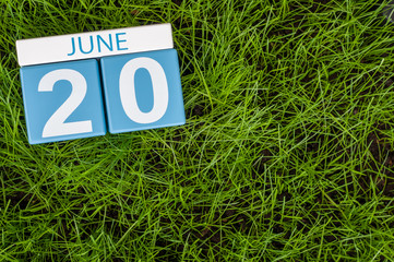 June 20th. Image of june 20 wooden color calendar on greengrass lawn background. Summer day, empty space for text