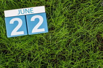 June 22nd. Image of june 22 wooden color calendar on greengrass lawn background. Summer day, empty...