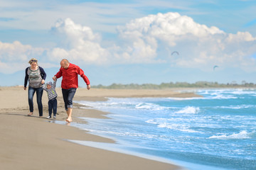 View of happy young family having fun on the beach