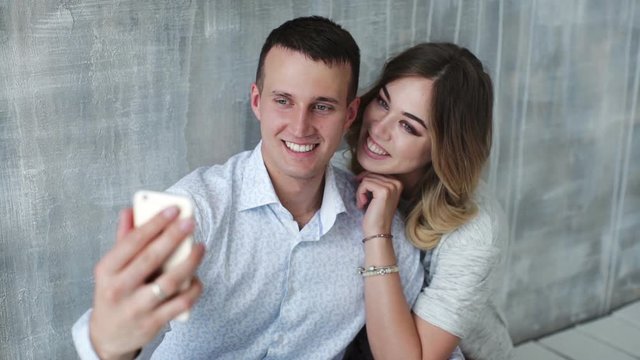 Happy young couple laughing and making selfie