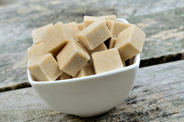 Sugar brown cubes in white bowl
