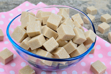 Sugar brown cubes in transparent bowl