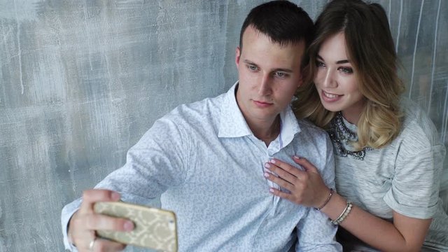 Couple taking self portrait with smart phone. Beautiful young couple selfie