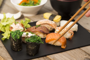 Sushi assortment on black dish, close up..