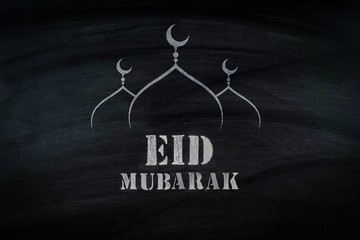 Eid Mubarak, traditional Muslim greeting . On black broad 