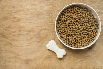 Dog bone and dog food on wood table