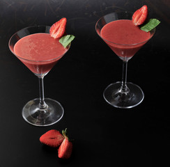 Strawberry smoothie in cocktail glass with strawberry and mint o