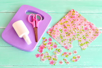 Painted wooden kitchen board. Wooden handmade chopping board kitchen decor. Paper napkin, cut floral fragments, scissors. Decoration items. Set for decoupage, recycled crafts