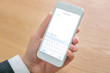 businessman holds mobile phone in office