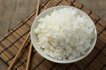 Steamed rice close-up with chopsticks on a bamboo mat