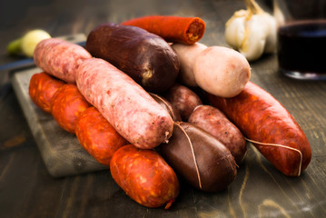 Spanish raw sausages on rustic wooden - obrazy, fototapety, plakaty