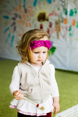 beautiful little girl draws on the wall with paints, brushes for painting, freehand drawing