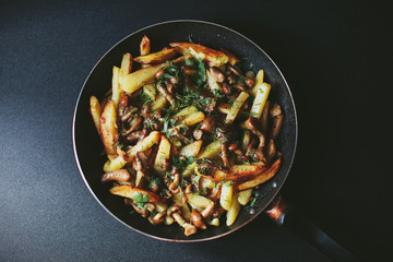 potatoes with mushrooms in a frying pan