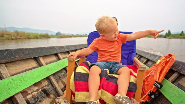 Toddler boy enjoys the boat trip on the Inle Lake in Myanmar (formerly Burma)