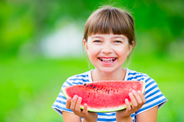 Child eating watermelon. Kids eat fruits in the garden. Pre teen girl in the garden holding a slice...