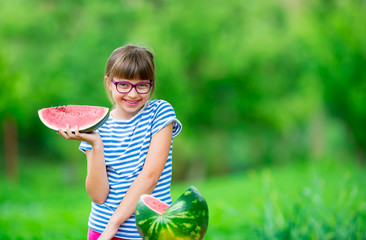 Child eating watermelon. Kids eat fruits in the garden. Pre teen girl in the garden holding a slice...