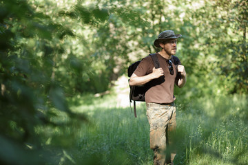 Fototapeta premium Male tourist walking alone in forest