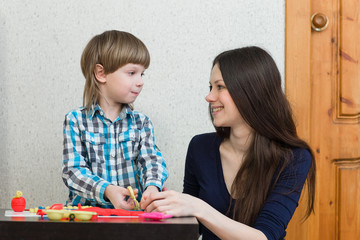 child kid boy and mother play colorful clay