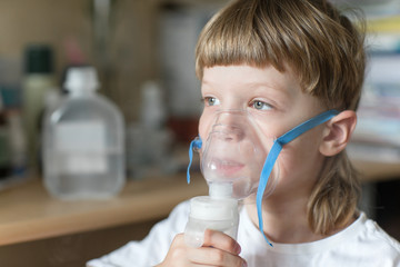 child holds a mask vapor inhaler