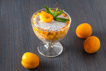 Raw vegan dessert: Chia seeds pudding with apricots on a wooden background 