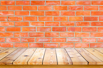 Empty wooden table with red brick wall background.