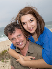 Cheerful and in love couple cuddling at the beach