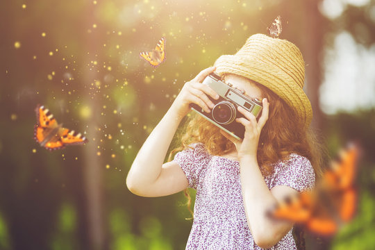 Little girl photographing butterfly