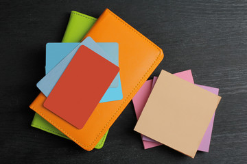 notebooks with stickers and credit cards on black wooden background