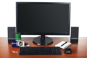 monitor with accessories and office items on a wooden table isolated on white background