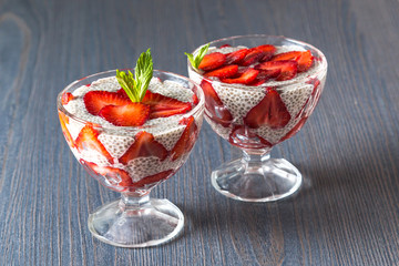 Raw vegan dessert: Chia seeds pudding with strawberries on a dark background