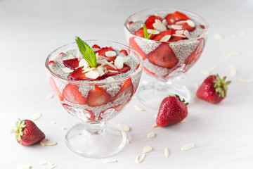 Raw vegan dessert: Chia seeds pudding with strawberries on a light background