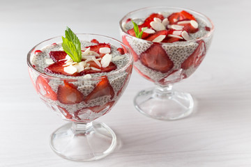 Raw vegan dessert: Chia seeds pudding with strawberries on a light background