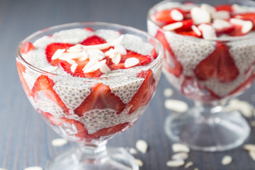 Raw vegan dessert: Chia seeds pudding with strawberries on a dark background