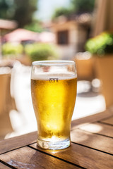 Glass of light beer on the wooden table.
