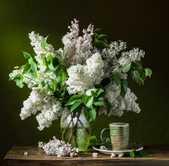 Lilac bouquet on the wooden table.