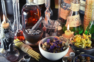 Close up of alchemy laboratory with candles and flowers