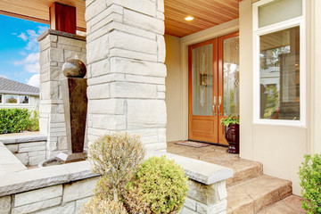 Luxury house entrance porch with stone column trim and stained w