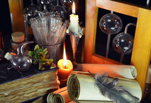 Two candles with magic bottles and vintage books