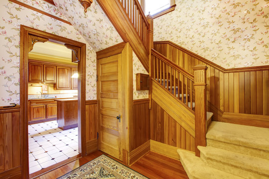 Entrance hallway with wooden staircase, beige carpet covered ste