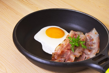 fried egg with bacon in the pan