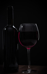 Elegant red wine glass and a wine bottle