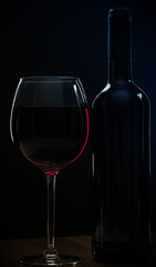 Elegant red wine glass and a wine bottle
