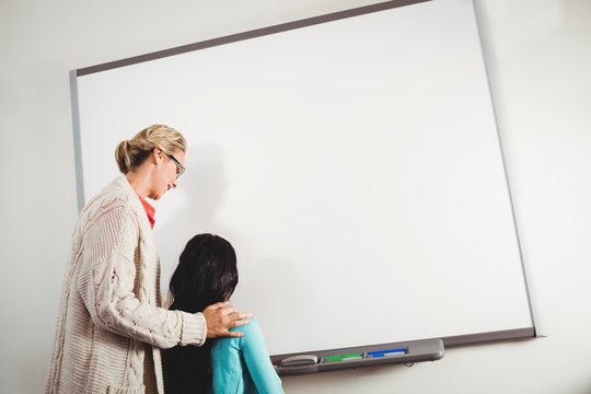 Teacher And Pupil Writing On Whiteboard