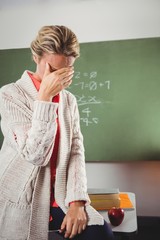 Teacher crying in front of blackboard