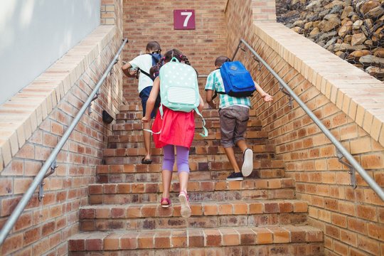 Three School Kids Climbing Brick Stairs